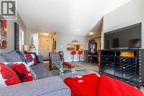 Burlington condo for rent - A living room with a grey couch and red pillows.