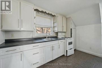 Kitchener duplex for rent - A kitchen with white cabinets and a black countertop.