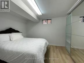 Richmond Hill (Crosby) apartment for rent - A bedroom with a bed, wooden floor, and a glass walled closet.