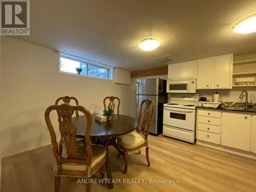 Richmond Hill (Crosby) apartment for rent - A kitchen with a table and chairs in the foreground and a refrigerator, microwave, oven, and sink in the background.