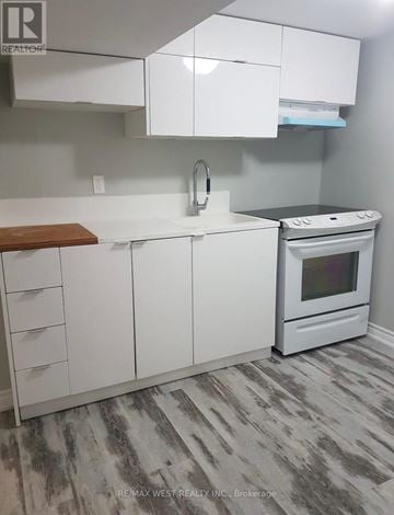 Toronto (Mimico) apartment for rent - A white kitchen with a stove and a sink.