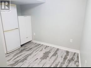 Toronto (Mimico) apartment for rent - A room with a white fridge and cabinets.