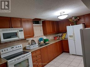 Brampton (Heart Lake West) apartment for rent - A kitchen with brown cabinets and white appliances.