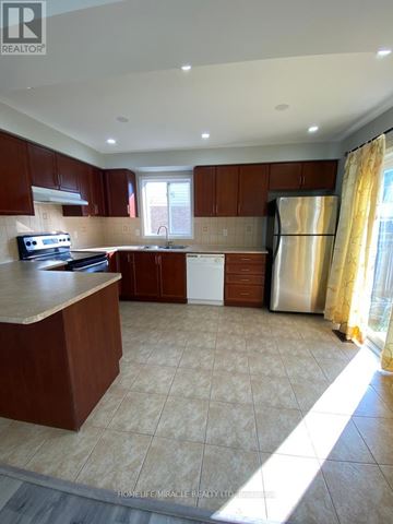 Brampton (Credit Valley) duplex for rent - A kitchen with brown cabinets and a white refrigerator.