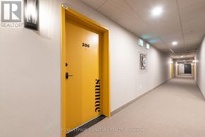 Barrie condo for rent - A hallway with a yellow door labeled 306 and a sign that says "Royal LePage Signature Realty, Brokerage.".
