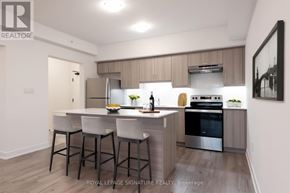 Barrie condo for rent - A modern kitchen with a bar area and a fridge on the counter.