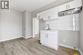 Wallaceburg apartment for rent - A kitchen area with white cabinets and a sink.