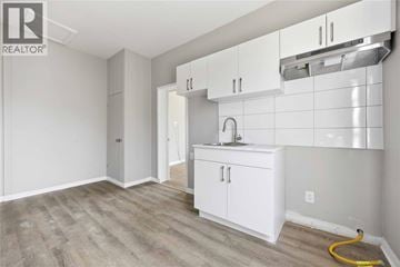 Wallaceburg apartment for rent - A kitchen area with white cabinets and a sink.