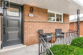 Hamilton (Corman) apartment for rent - A house number 69 with a black door and a small patio with chairs.