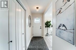 Hamilton (Corman) apartment for rent - A hallway with a white door, a plant, and a painting of birds.