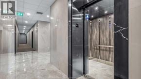 Windsor condo for rent - A hallway with a marble floor and a glass door leading to another room.