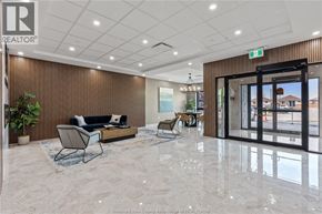 Windsor condo for rent - A modern office lobby with a black sofa and a glass door leading outside.