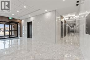 Windsor condo for rent - A hallway with a marble floor and a white ceiling with lights.
