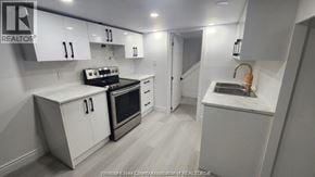 Windsor apartment for rent - A kitchen with white cabinets and a black stove top oven.