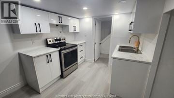 Windsor apartment for rent - A kitchen with white cabinets and a black stove top oven.