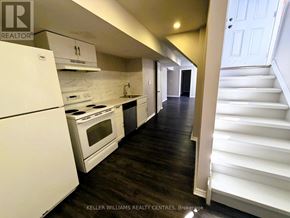 Barrie (Little Lake) apartment for rent - A white kitchen with a white fridge and stove.