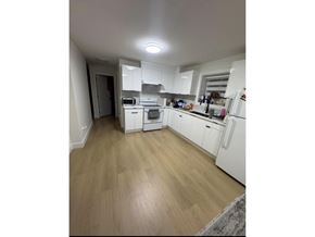 Surrey apartment for rent - A kitchen with white appliances and wooden floors.