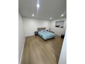 Surrey apartment for rent - A bedroom with a bed and a suitcase.