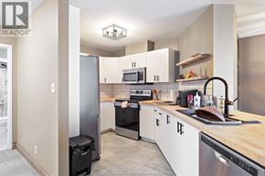 Windsor condo for rent - A kitchen with white cabinets and a black fridge.
