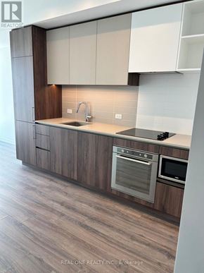 Vaughan (Vaughan Corporate Centre) condo for rent - A modern kitchen with wooden cabinets and stainless steel appliances.