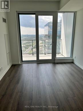 Vaughan (Vaughan Corporate Centre) condo for rent - A room with a view of a highway and buildings outside a sliding glass door.