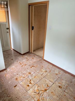 Toronto (Alderwood) apartment for rent - A room with a tile floor and a wooden door.