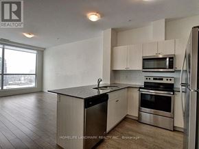 Kitchener condo for rent - A kitchen with a refrigerator, microwave, oven, and sink.