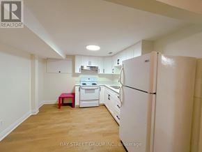 St. Catharines (Glendale/Glenridge) apartment for rent - A kitchen with white appliances and wooden floors.