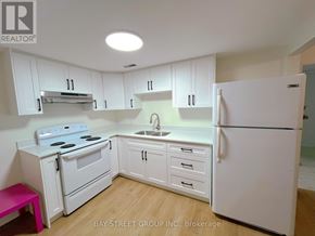 St. Catharines (Glendale/Glenridge) apartment for rent - A kitchen with white appliances and cabinets.