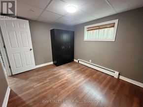 St. Catharines (Burleigh Hill) apartment for rent - A room with a white door, a black cabinet, and a window with blinds.