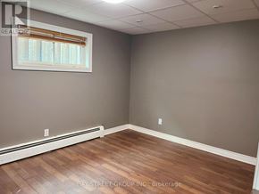 St. Catharines (Burleigh Hill) apartment for rent - A room with wooden flooring and a window with blinds.