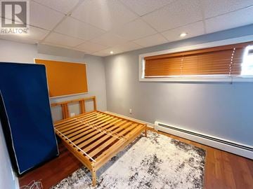 St. Catharines (Burleigh Hill) apartment for rent - A bedroom with a wooden bed and a blue wardrobe.