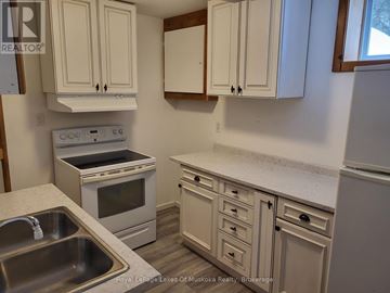 Huntsville (Chaffey) apartment for rent - A kitchen with white cabinets and a stove top oven.