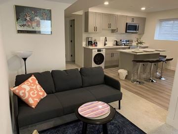 Langley apartment for rent - A black couch with a red pillow sits in a living room.