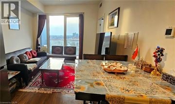 Kitchener condo for rent - A living room with a dining table set for two with a view of the city.