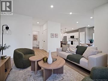 Moncton apartment for rent - A modern living room with a grey couch and a wooden coffee table.