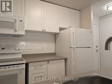 Ottawa multi-family for rent - A kitchen with white cabinets and appliances.