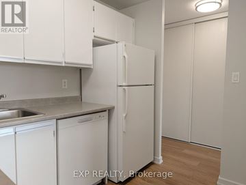 Ottawa multi-family for rent - A kitchen with white cabinets and a white refrigerator.
