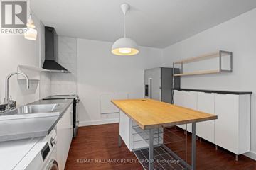 Ottawa triplex for rent - A kitchen with a wooden table and stainless steel appliances.