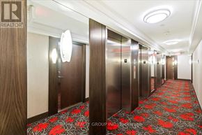 Toronto (Etobicoke West Mall) condo for rent - A hallway with elevators and a logo on the wall.