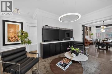 Hamilton apartment for rent - A living room with a black leather sofa and a television.