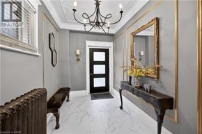Hamilton apartment for rent - A hallway with a chandelier, a mirror, and a bench.
