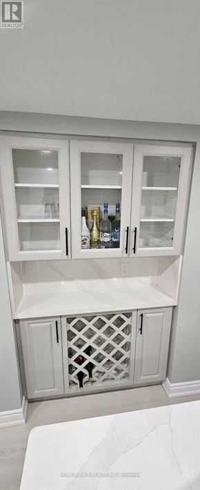 Markham (Raymerville) apartment for rent - A white cabinet with glass doors and a wine bottle inside.