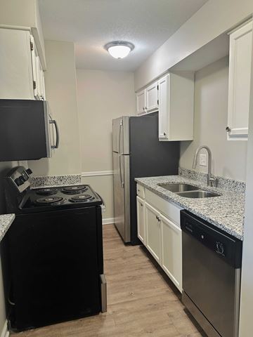 Shawnee apartment for rent - A kitchen with black appliances and white cabinets.