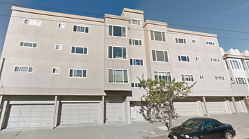 San Francisco apartment for rent - A black car is parked in front of a tan building.