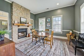 Reynoldsburg apartment for rent - A cozy living room with a fireplace and a dining table set up.