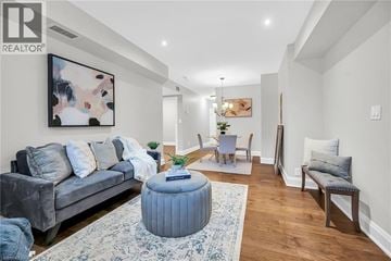 Hamilton condo for rent - A living room with a grey couch, a blue ottoman, and a painting on the wall.