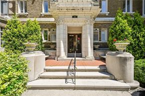 Hamilton condo for rent - A building with a large front porch and a bench in front.