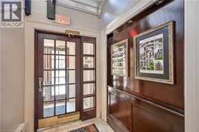 Hamilton condo for rent - A brown door with a glass window and a red exit sign above it.