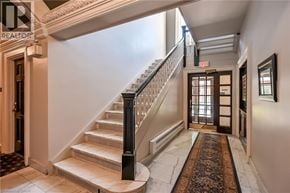 Hamilton condo for rent - A hallway with a staircase and a door at the end.